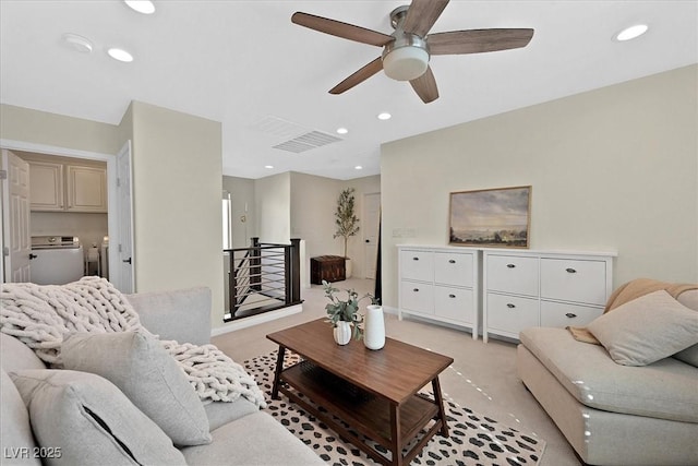 carpeted living room with washing machine and dryer