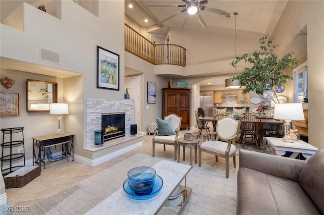 tiled living room with ceiling fan and high vaulted ceiling