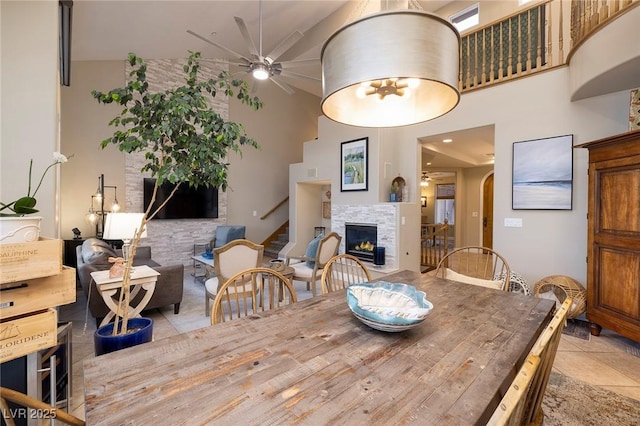 dining area featuring light tile patterned flooring, ceiling fan, and a high ceiling