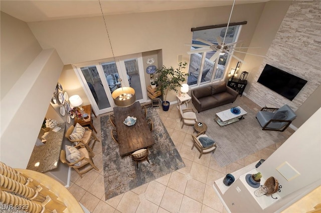 tiled living room with a towering ceiling and ceiling fan