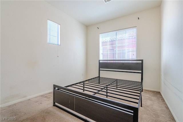 bedroom with multiple windows and light carpet