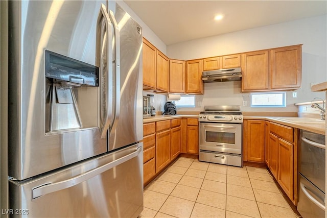 kitchen with light tile patterned flooring, appliances with stainless steel finishes, and sink