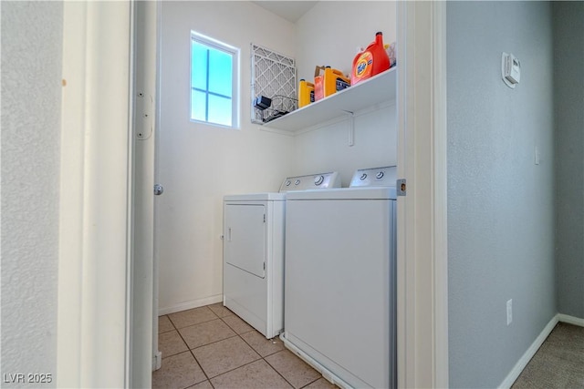 clothes washing area featuring light tile patterned floors and washing machine and clothes dryer