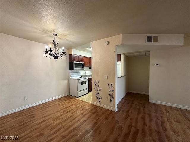 kitchen featuring white electric stove, a chandelier, hardwood / wood-style floors, and a textured ceiling