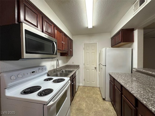 kitchen with sink, white appliances, and a textured ceiling