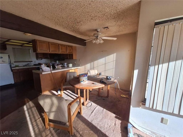 kitchen with ceiling fan, white fridge, and a textured ceiling