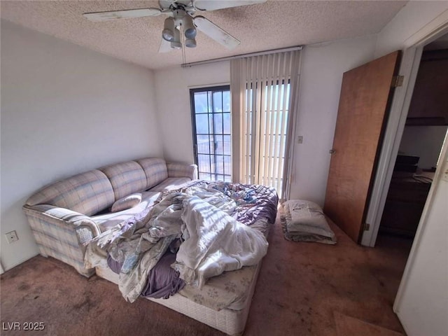 bedroom with ceiling fan, a textured ceiling, and dark colored carpet