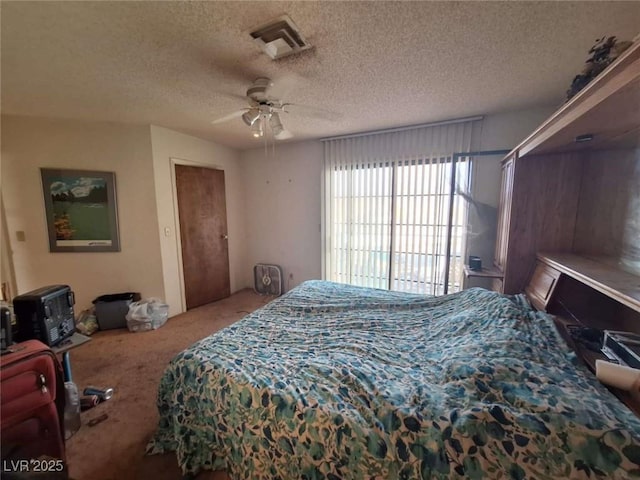 bedroom featuring ceiling fan, carpet floors, and a textured ceiling