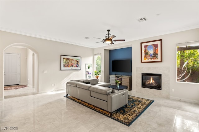 living room with crown molding, a fireplace, and ceiling fan