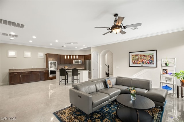 living room featuring ornamental molding and ceiling fan