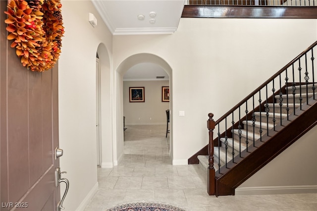 entrance foyer with ornamental molding and light tile patterned floors