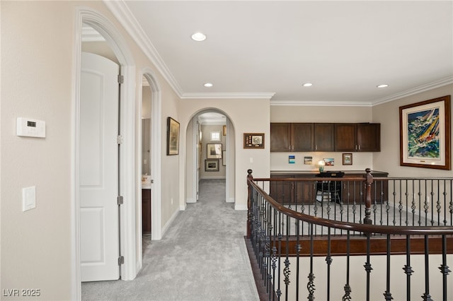 hall with crown molding and light carpet