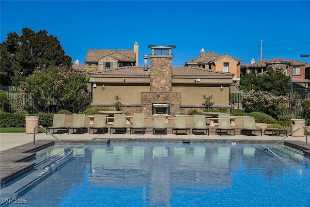 view of pool with a patio and an outdoor stone fireplace