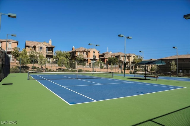 view of tennis court with basketball hoop