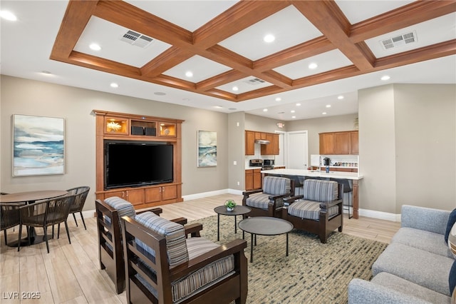 living room featuring beam ceiling, coffered ceiling, sink, and light wood-type flooring