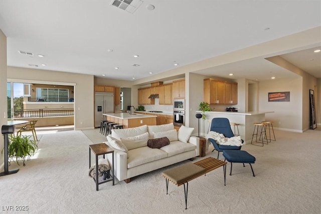 living room featuring light carpet and sink