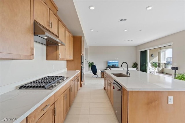 kitchen with sink, stainless steel appliances, an island with sink, and light tile patterned flooring