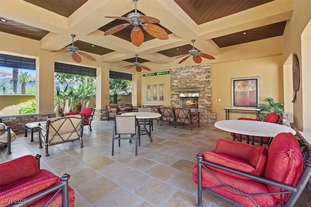 interior space with an outdoor living space with a fireplace and ceiling fan