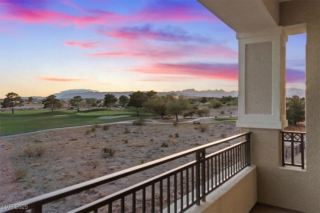 balcony at dusk featuring a mountain view