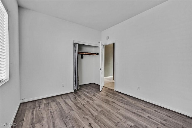 unfurnished bedroom with light wood-type flooring and a closet