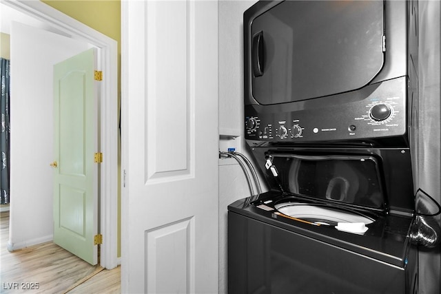 laundry area with stacked washer / dryer and light hardwood / wood-style floors