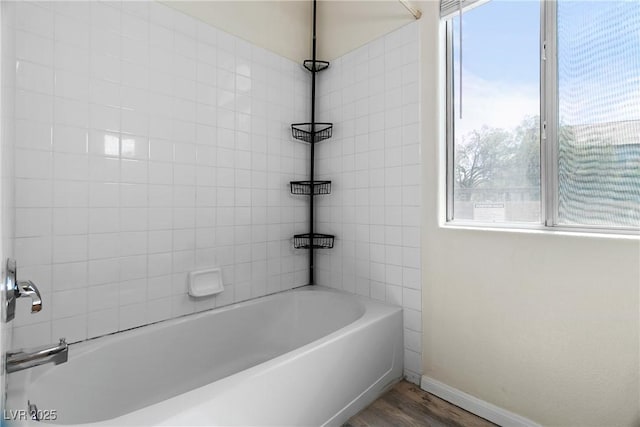 bathroom featuring tiled shower / bath combo and hardwood / wood-style floors