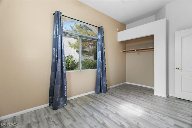 unfurnished bedroom featuring light wood-type flooring and a closet