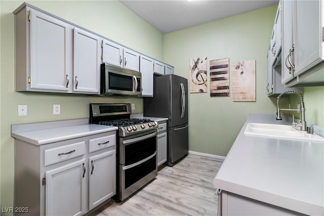 kitchen featuring sink, light hardwood / wood-style floors, and appliances with stainless steel finishes