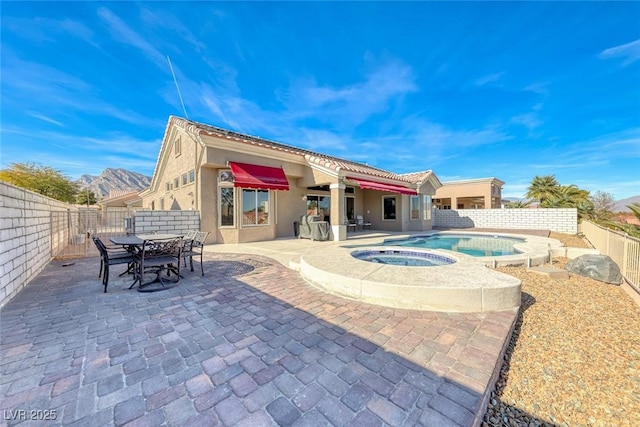 exterior space with an in ground hot tub, outdoor dining area, and a fenced backyard