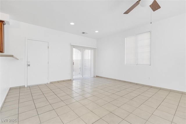 tiled spare room with ceiling fan