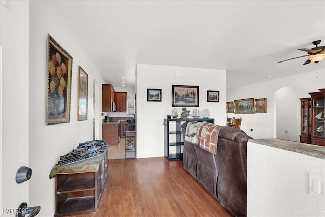 living room with wood-type flooring and ceiling fan