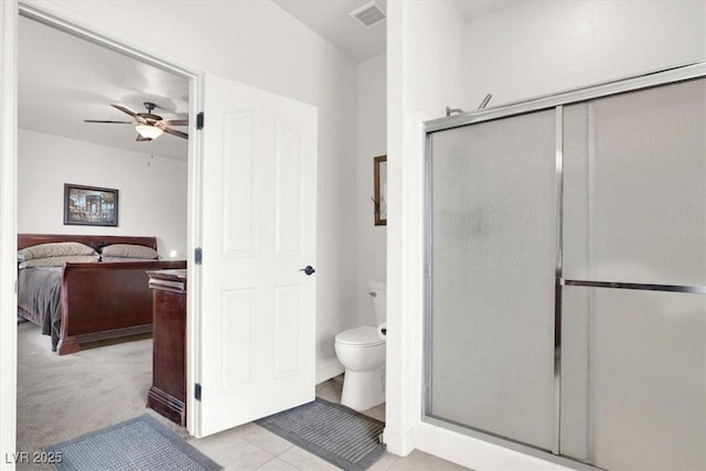 bathroom with tile patterned floors, toilet, ceiling fan, and walk in shower