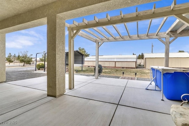 view of patio / terrace with a pool, a pergola, and a storage shed