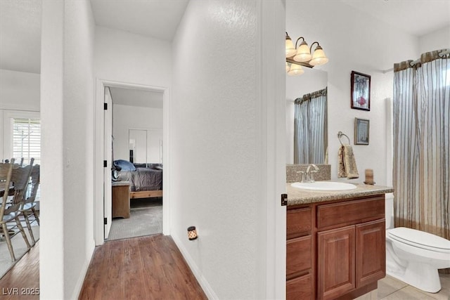 bathroom featuring vanity, hardwood / wood-style floors, and toilet