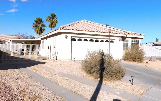 view of side of property with a garage, a tile roof, fence, and stucco siding