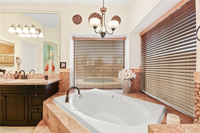 bathroom featuring vanity, tile patterned floors, tiled bath, and a chandelier