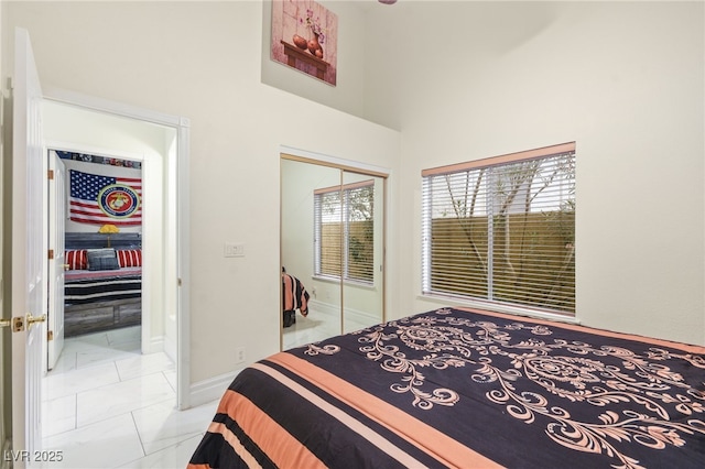 tiled bedroom featuring a towering ceiling and a closet