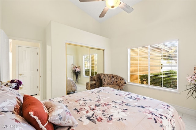 bedroom with multiple windows, lofted ceiling, a closet, and ceiling fan