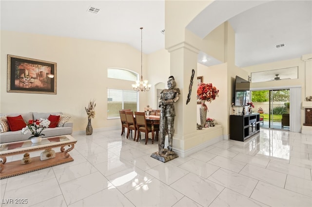 living room featuring ceiling fan with notable chandelier and high vaulted ceiling