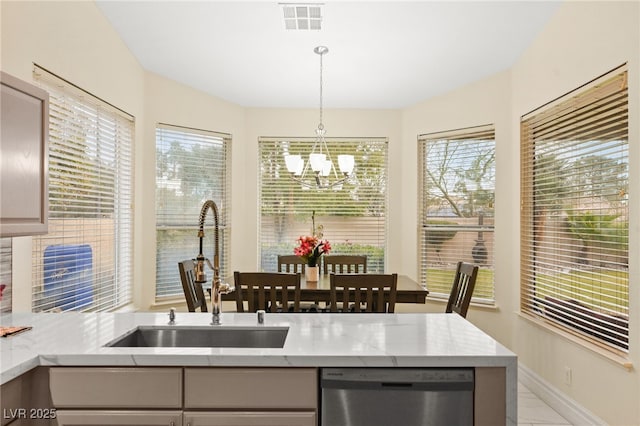 kitchen featuring gray cabinets, pendant lighting, sink, stainless steel dishwasher, and an inviting chandelier