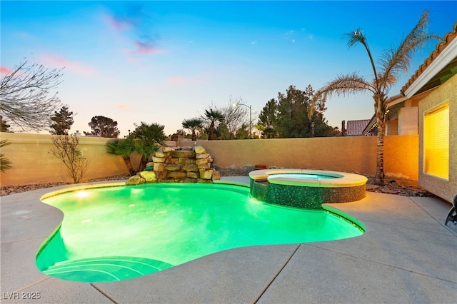 pool at dusk featuring an in ground hot tub and a patio