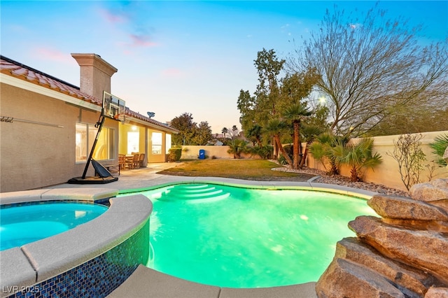 pool at dusk featuring a patio area