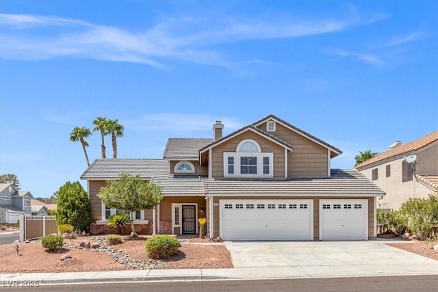 traditional home with a chimney, driveway, and a tiled roof