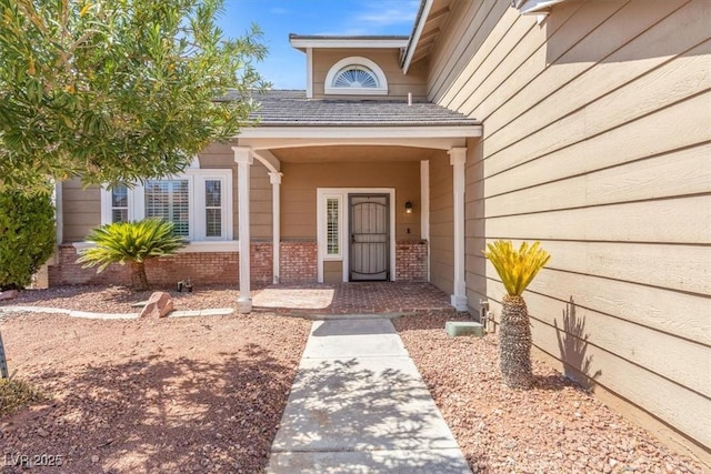 view of exterior entry featuring brick siding