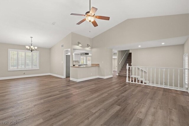 unfurnished living room with dark wood-type flooring, lofted ceiling, and ceiling fan with notable chandelier