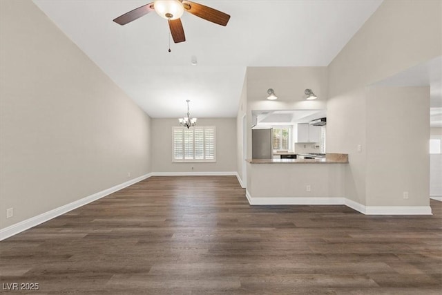 unfurnished living room with dark wood-type flooring, lofted ceiling, baseboards, and ceiling fan with notable chandelier