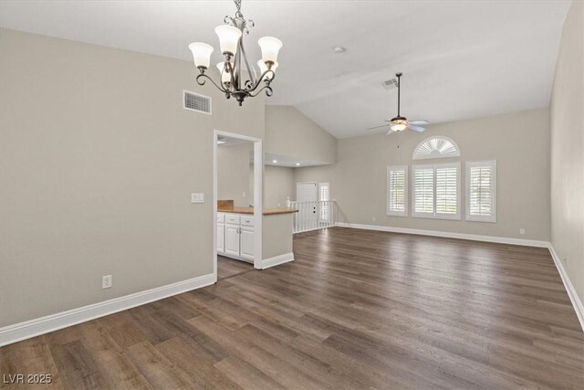 unfurnished living room featuring vaulted ceiling, dark wood-type flooring, and ceiling fan with notable chandelier