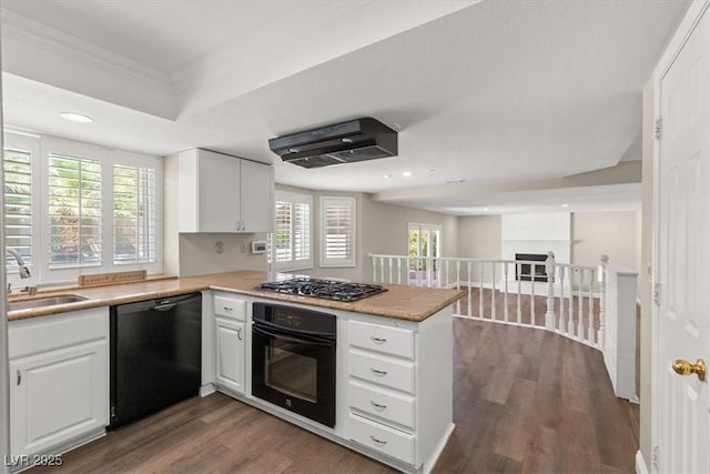 kitchen with white cabinetry, a peninsula, and black appliances