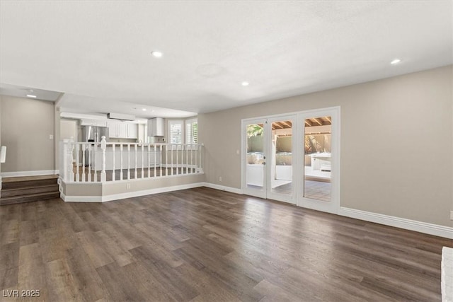 empty room featuring dark wood-type flooring, recessed lighting, and baseboards