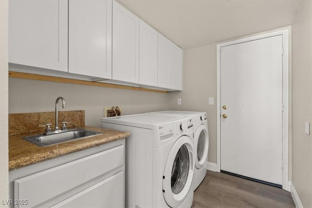 laundry area with cabinet space, baseboards, independent washer and dryer, light wood-type flooring, and a sink